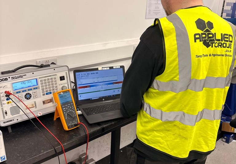 Measuring Instrument Calibration Service action shot of Applied Torque service technician Calibrating an electrical multimeter alongside Fluke Instruments.
