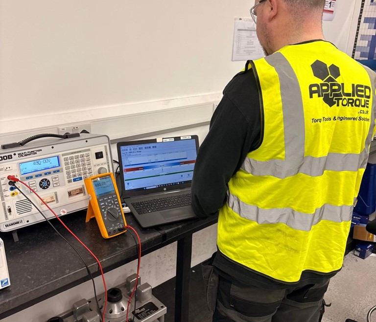 Measuring Instrument Calibration Service action shot of Applied Torque service technician Calibrating an electrical multimeter alongside Fluke Instruments.