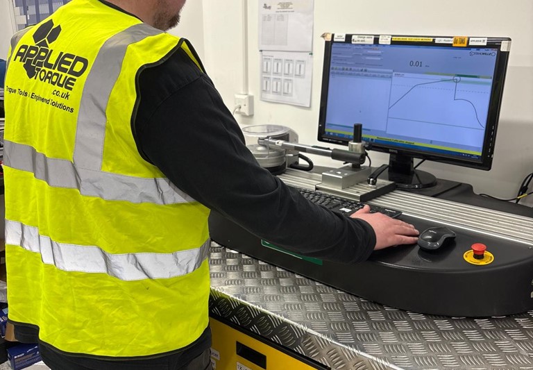 Torque Wrench Calibration Tool demonstration for an applied torque calibration technician. Torque wrench undergoing testing and issuing certification of compliance with UKAS & ISO standards.