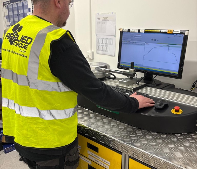 Torque Wrench Calibration Tool demonstration for an applied torque calibration technician. Torque wrench undergoing testing and issuing certification of compliance with UKAS & ISO standards.
